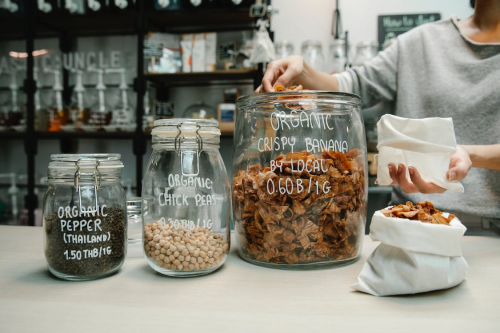 An image of a variety of different organic food products in glass jars on a counter in a shop