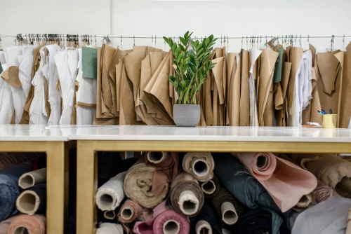 An image of rolls of assorted fabrics, textiles, and sewing patterns inside a retail shop