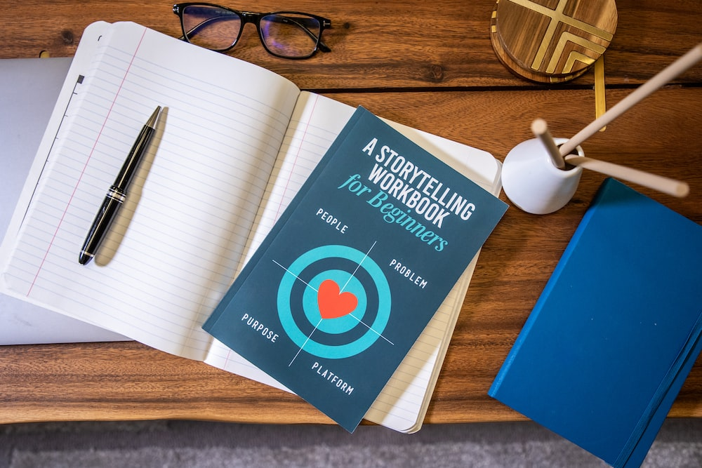A notebook with pen and a book on brand storytelling strategies.