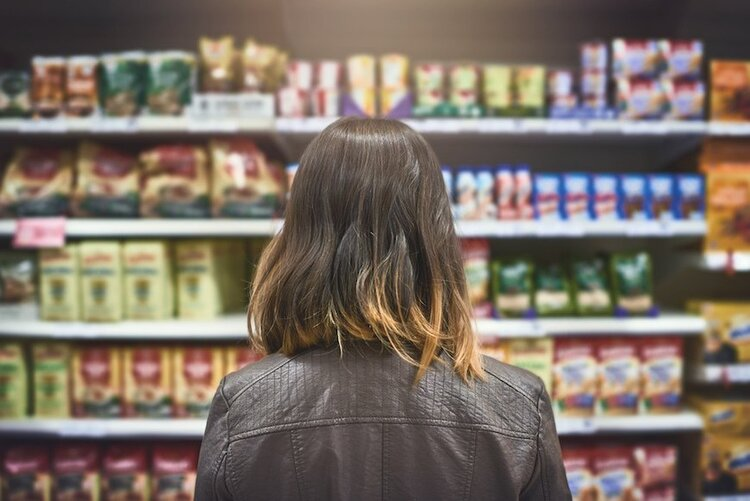 Picture8 A lady standing in front of a shelf in a grocery store
