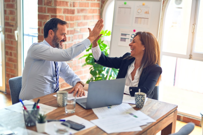 two coworkers high-fiving each other