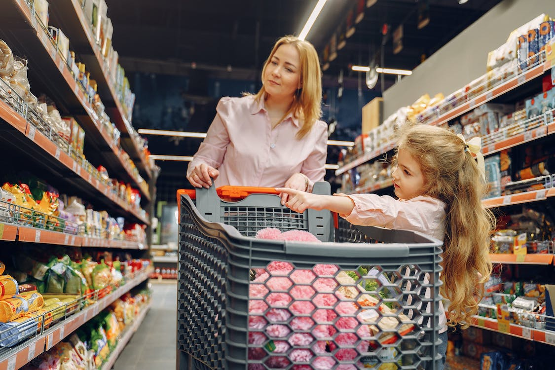 A mother and her daughter shopping for groceries.