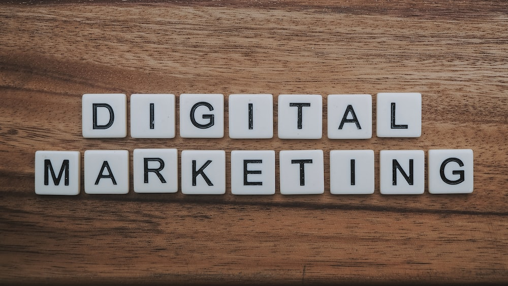"Scrabble tiles arranged to spell 'Digital Marketing' on a wooden tabletop.