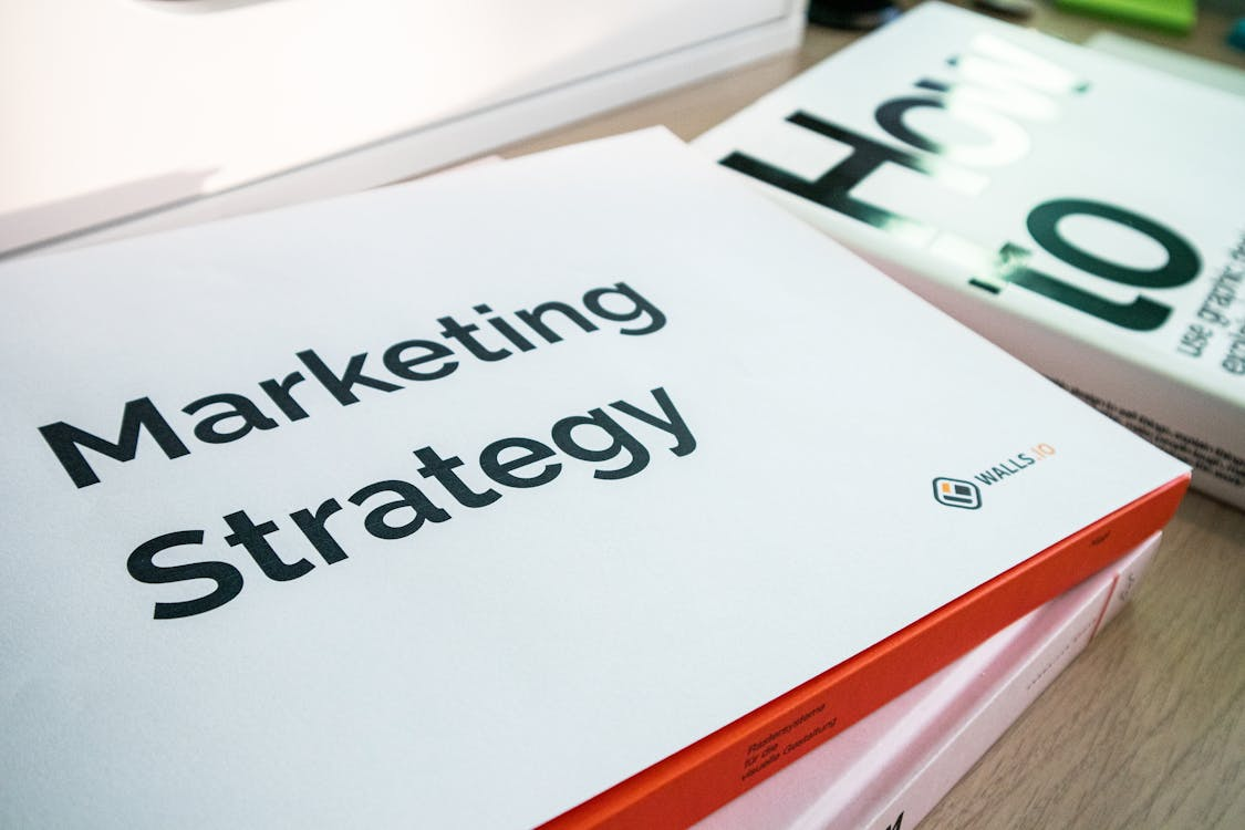 An image showing “Marketing Strategy” written on a white paper