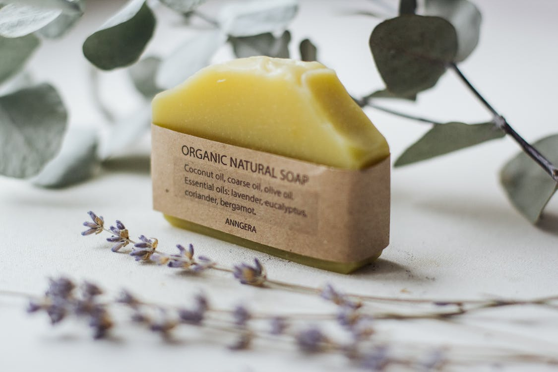 Aromatic natural soap placed near flowers