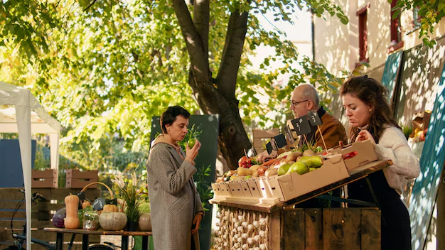 A woman selecting produce from a farmers market, highlighting the importance of strategic shelf placement for consumer purchasing decisions.