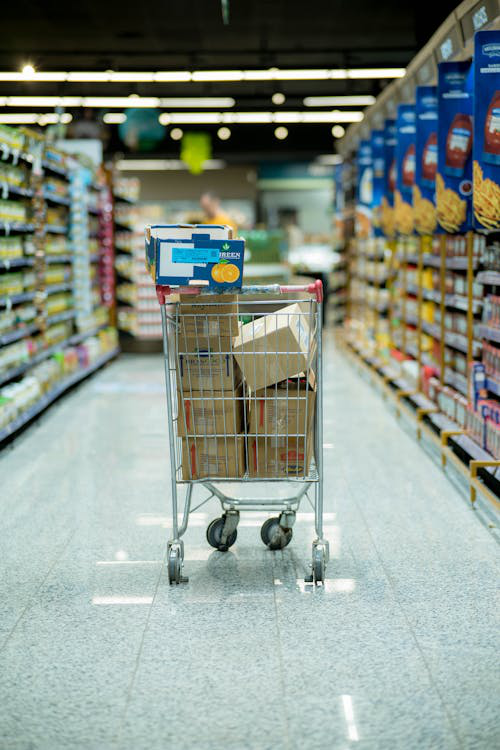 An image of a shopping cart filled with boxes in an empty aisle