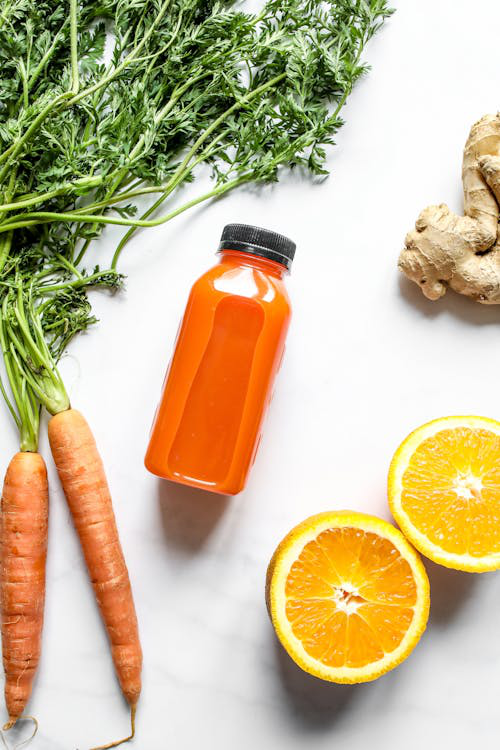 An image of a bottle of natural beverage with fruits and vegetables on a white background